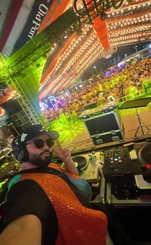 Frutamannn DJ en escenario de evento masivo en Barranquilla con traje de lentejuelas naranja