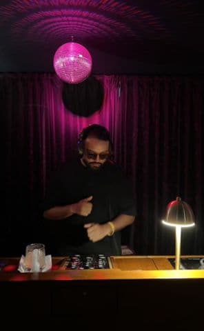 Frutamannn DJ bailando en set nocturno con bola disco en bar de Barranquilla
