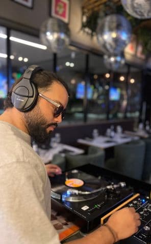 Frutamannn DJ tocando vinilo en tornamesa en restaurante de Barranquilla